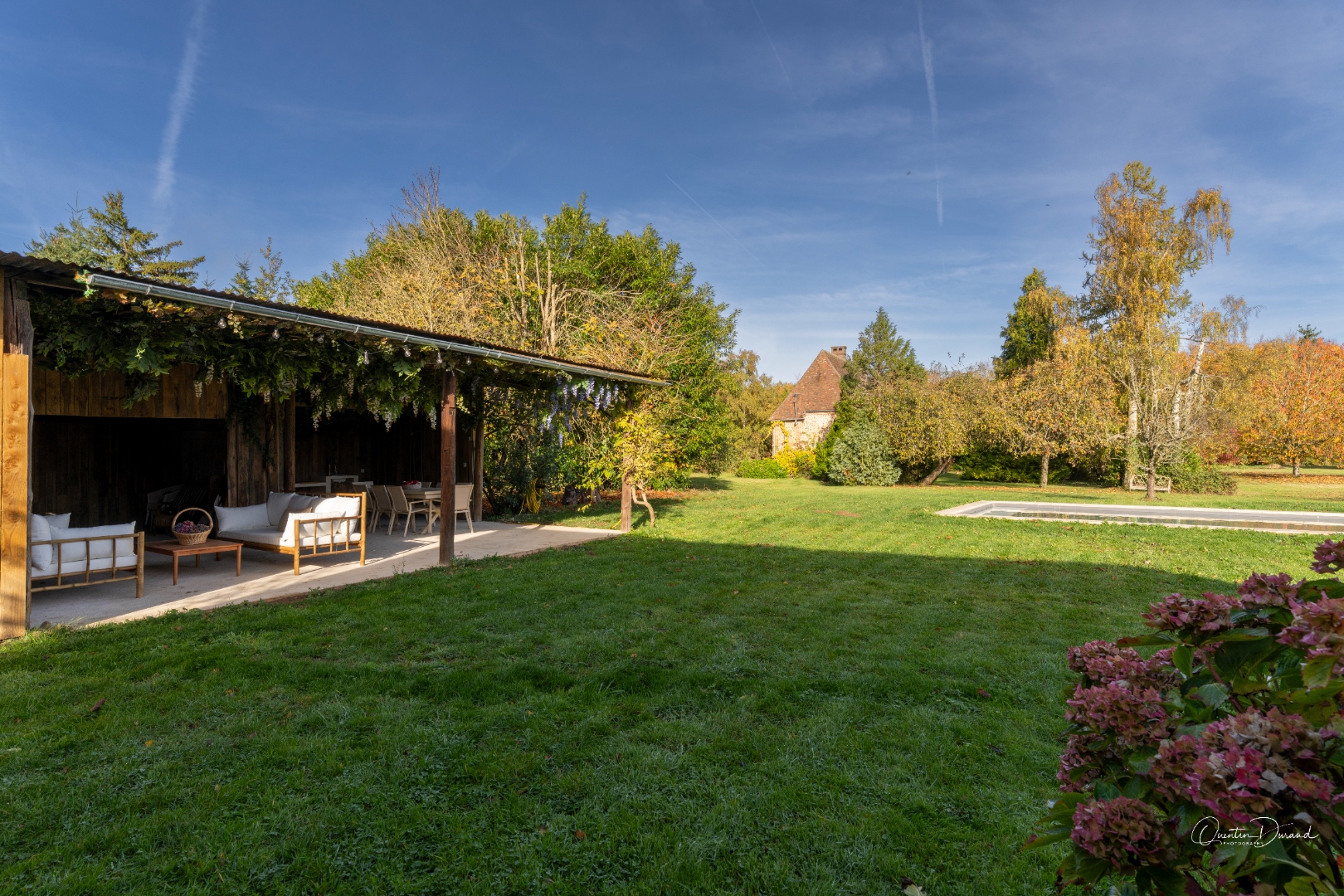 Détail du salon extérieur couvert avec canapés et table