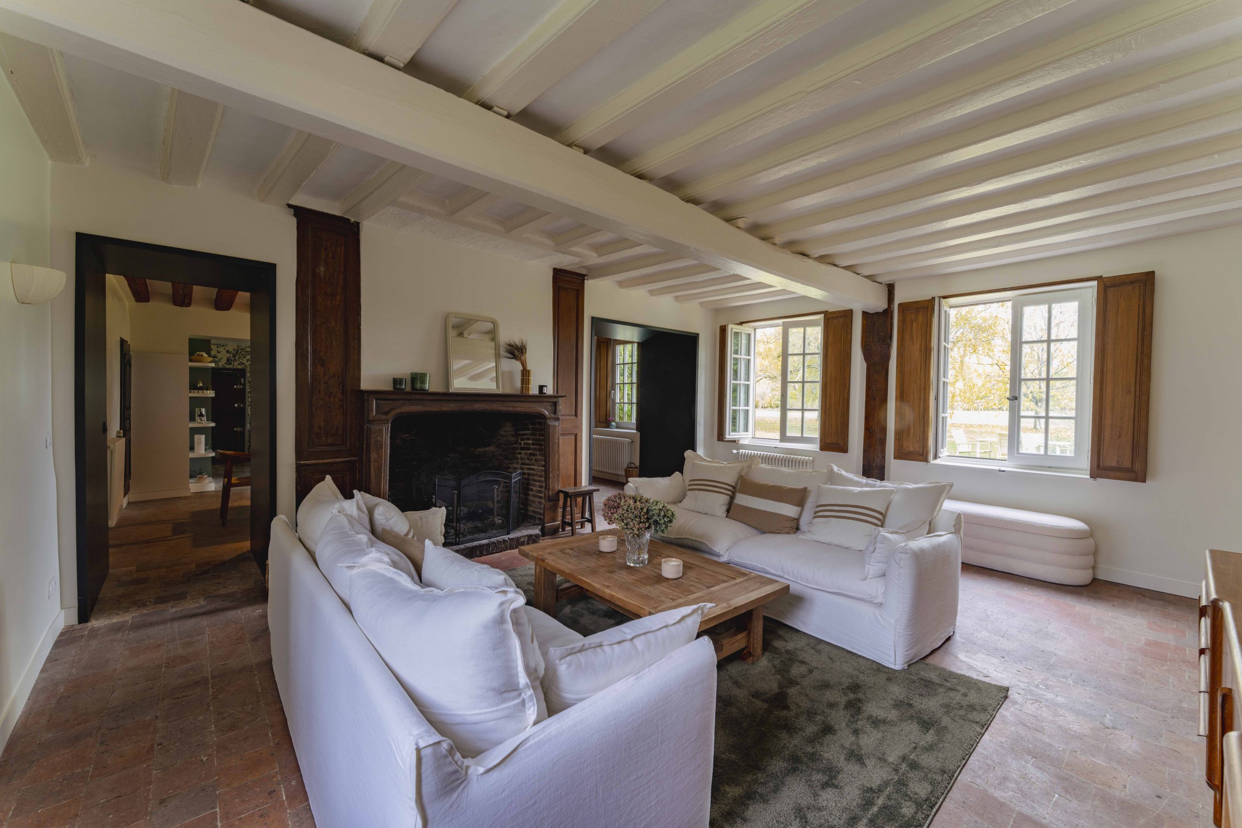 Grand salon avec cheminée et canapés